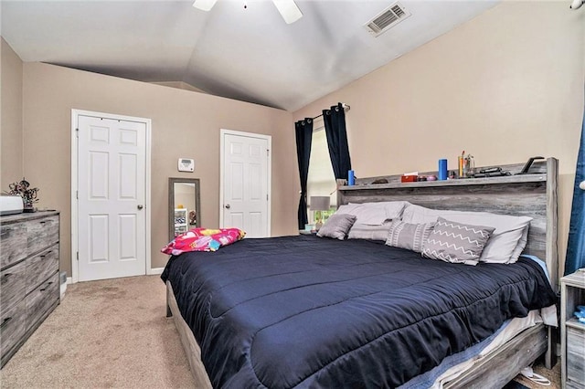 carpeted bedroom with a ceiling fan, visible vents, and vaulted ceiling