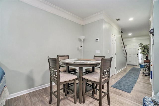 dining area featuring recessed lighting, light wood-style flooring, baseboards, and ornamental molding