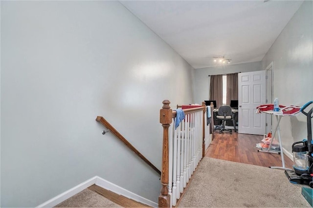 staircase with baseboards and wood finished floors