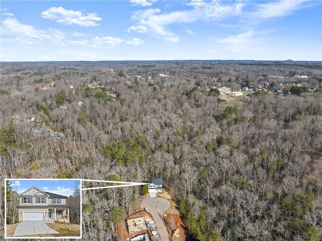 drone / aerial view featuring a wooded view