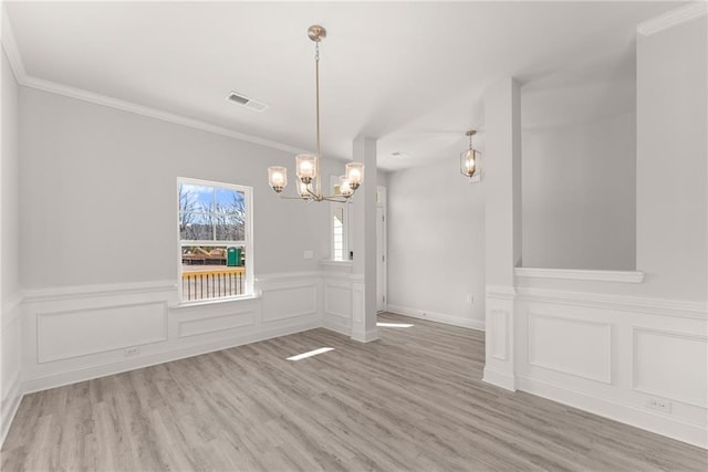 unfurnished dining area featuring visible vents, crown molding, wood finished floors, and a chandelier