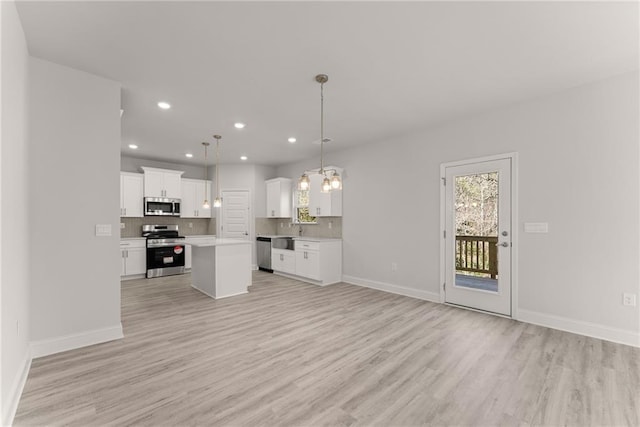 kitchen with open floor plan, backsplash, and appliances with stainless steel finishes