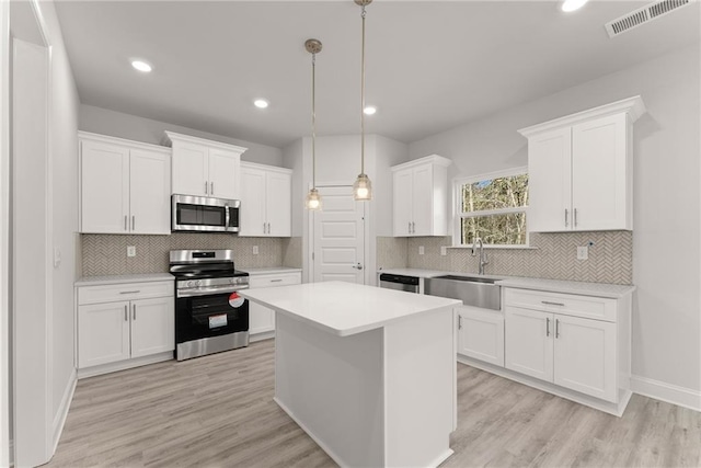 kitchen with white cabinetry, a sink, stainless steel appliances, and visible vents