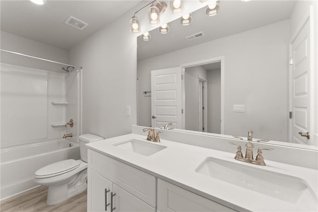 full bath featuring toilet, a sink, and visible vents