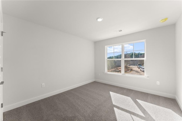 carpeted spare room with baseboards and visible vents