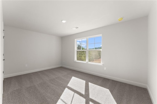unfurnished room with baseboards, visible vents, and carpet flooring