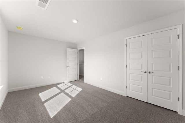 unfurnished bedroom featuring baseboards, visible vents, and carpet