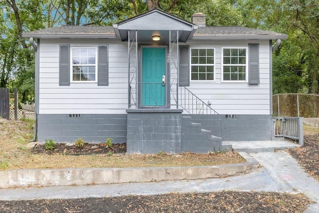 view of front of property with fence, a chimney, and crawl space