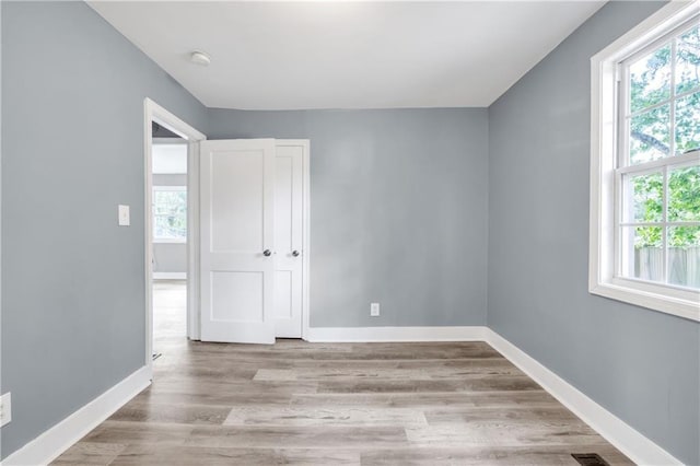 empty room featuring baseboards and light wood-type flooring