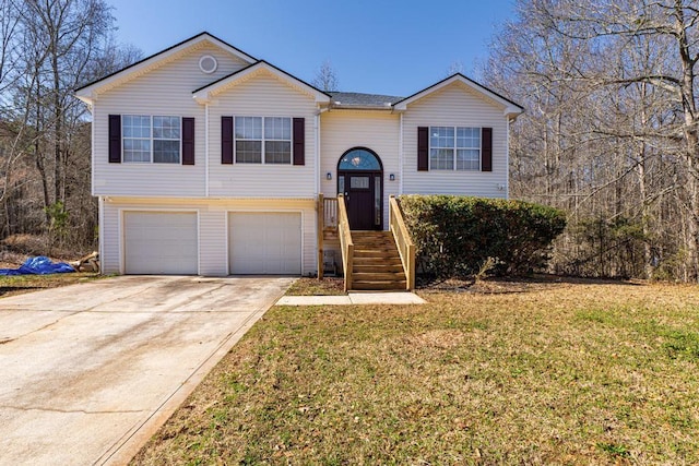 raised ranch featuring a garage and a front lawn