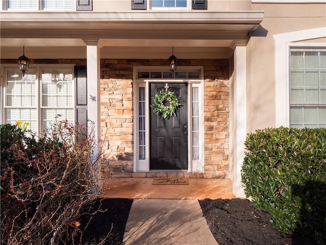 property entrance with stone siding and stucco siding