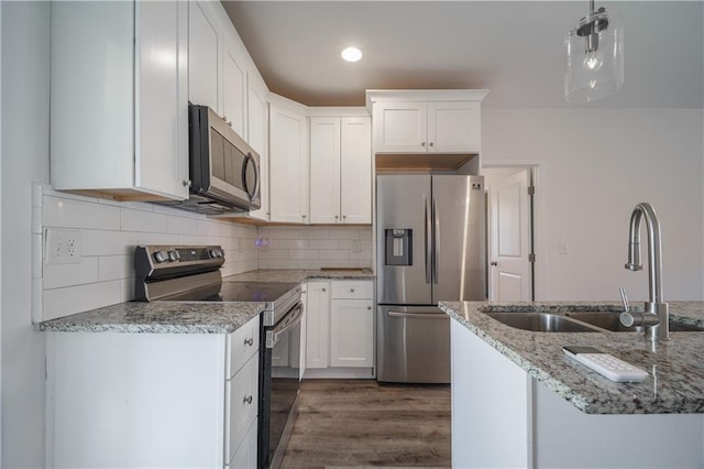 kitchen featuring light stone counters, dark wood-type flooring, white cabinets, and appliances with stainless steel finishes