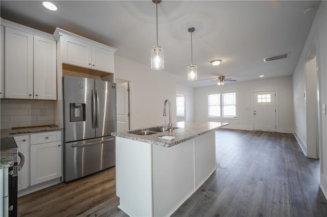 kitchen with white cabinetry, sink, stainless steel fridge, and decorative backsplash