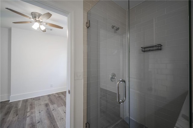 bathroom featuring an enclosed shower, wood-type flooring, and ceiling fan