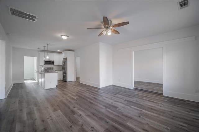 unfurnished living room with dark wood-type flooring and ceiling fan