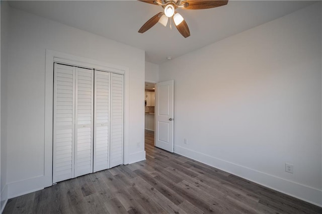 unfurnished bedroom featuring ceiling fan, wood-type flooring, and a closet