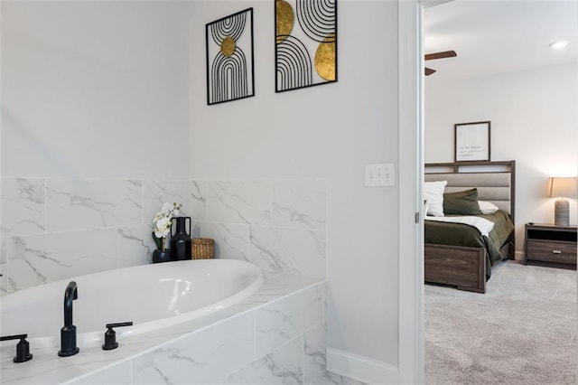 bathroom with a bath, baseboards, and ensuite bathroom