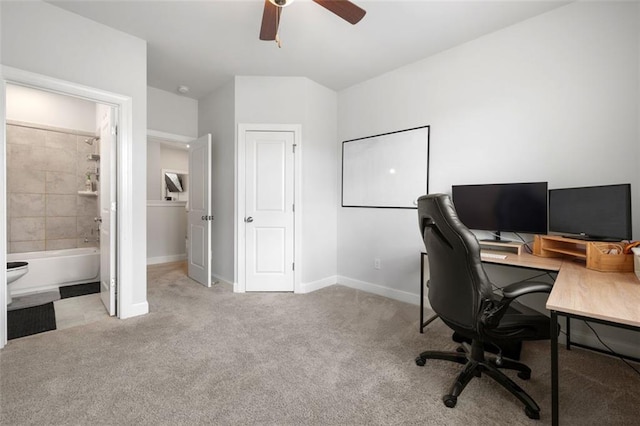 carpeted office featuring baseboards and a ceiling fan