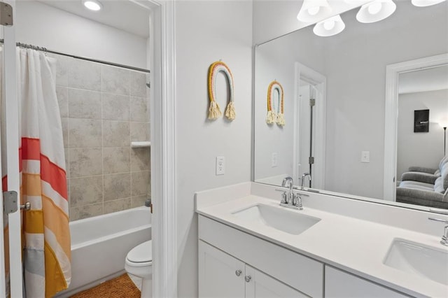 bathroom featuring double vanity, toilet, shower / tub combo with curtain, and a sink