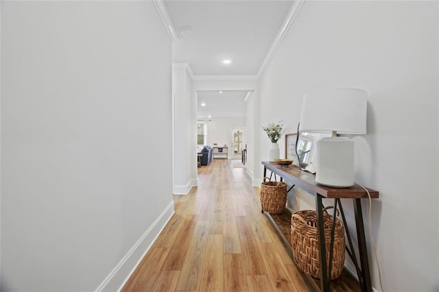 hallway featuring crown molding, recessed lighting, light wood-style floors, and baseboards