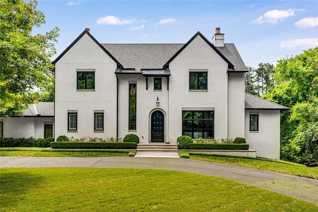 3773 Randall Rd SE, Atlanta, GA 30339 - french provincial home with a front yard, a chimney, stucco siding, and curved driveway