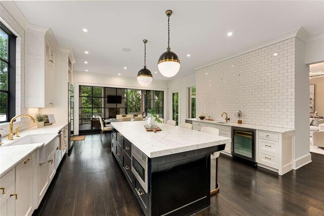 3773 Randall Rd SE, Atlanta, GA 30339 - kitchen featuring beverage cooler, a sink, white cabinets, decorative backsplash, and recessed lighting