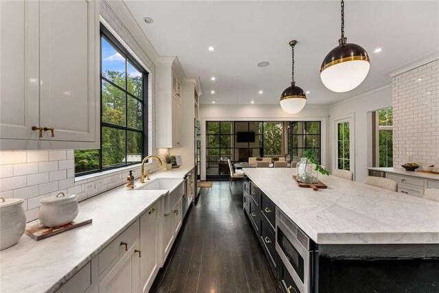 3773 Randall Rd SE, Atlanta, GA 30339 - kitchen featuring a sink, stainless steel microwave, a spacious island, dark wood-style flooring, and tasteful backsplash