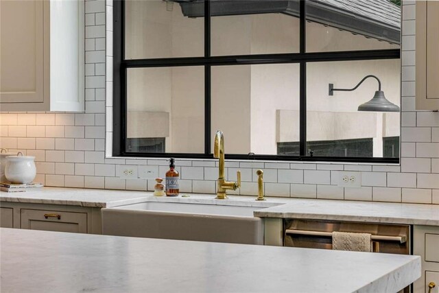 3773 Randall Rd SE, Atlanta, GA 30339 - kitchen featuring a sink, backsplash, light stone counters, and stainless steel dishwasher