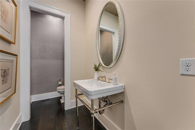 3773 Randall Rd SE, Atlanta, GA 30339 - bathroom featuring wood finished floors, toilet, baseboards, and a sink