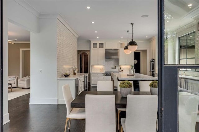 3773 Randall Rd SE, Atlanta, GA 30339 - dining area with crown molding, dark wood-style floors, baseboards, recessed lighting, and arched walkways