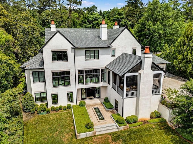 3773 Randall Rd SE, Atlanta, GA 30339 - back of property featuring a chimney, stucco siding, a sunroom, a lawn, and a shingled roof