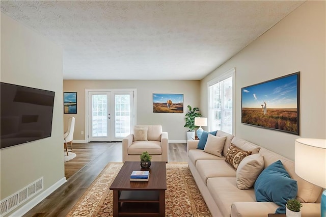 270 Hunt Ridge Dr, Stockbridge, GA 30281 - living room featuring dark wood finished floors, a textured ceiling, baseboards, and french doors