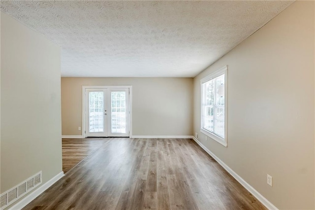 270 Hunt Ridge Dr, Stockbridge, GA 30281 - spare room with healthy amount of natural light, wood finished floors, baseboards, french doors, and a textured ceiling