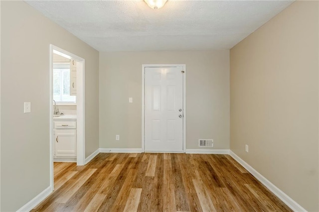 270 Hunt Ridge Dr, Stockbridge, GA 30281 - empty room with light wood-style flooring, baseboards, and a textured ceiling
