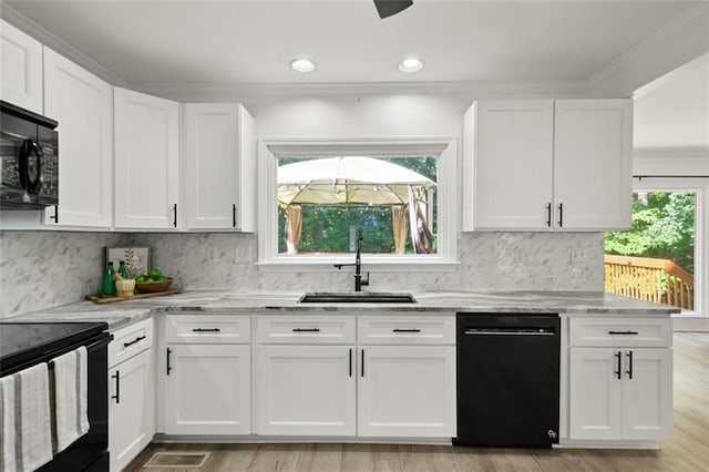 2316 Fripp Overlook NW, Acworth, GA 30101 - kitchen with black appliances, light stone countertops, white cabinets, ornamental molding, and recessed lighting