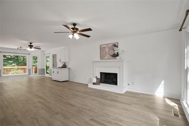 2316 Fripp Overlook NW, Acworth, GA 30101 - unfurnished living room with crown molding, a brick fireplace, light wood-type flooring, and a ceiling fan