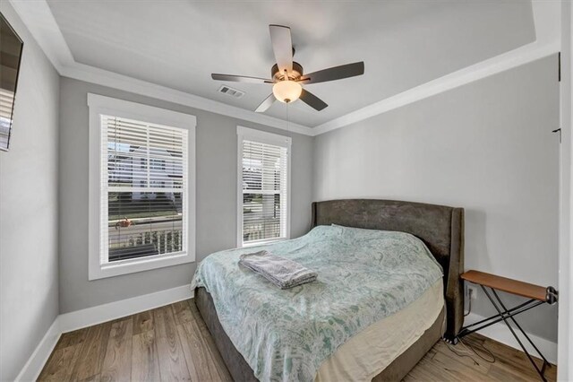 bedroom featuring ornamental molding, dark wood-type flooring, ceiling fan, and a closet