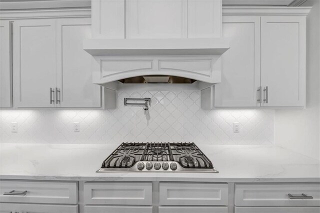 kitchen with appliances with stainless steel finishes, white cabinetry, a kitchen breakfast bar, hanging light fixtures, and a center island with sink