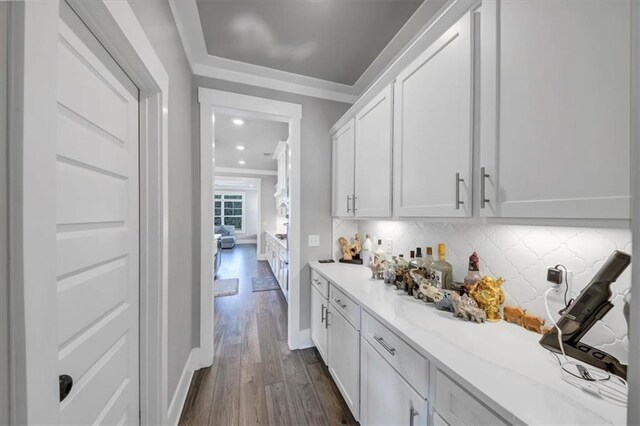 kitchen with light stone counters, backsplash, stainless steel gas cooktop, and white cabinets