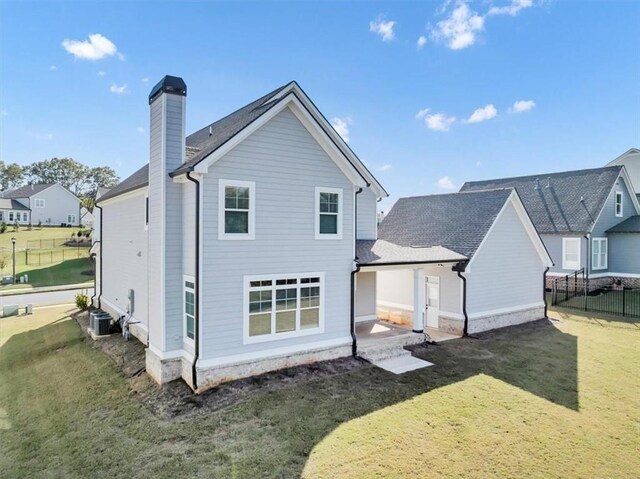 back of house with a patio and a lawn