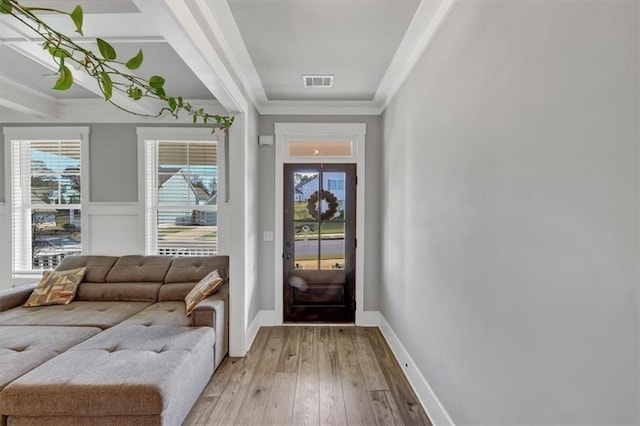 doorway featuring crown molding and light hardwood / wood-style floors