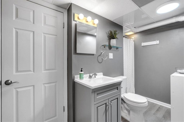full bathroom with vanity, wood finished floors, toilet, baseboards, and a shower with shower curtain