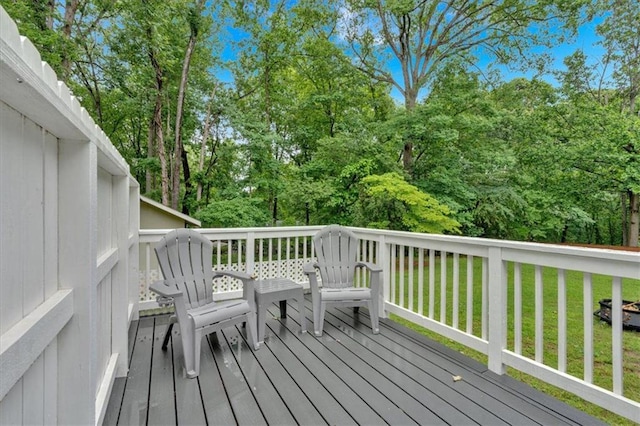 wooden deck with a yard and view of wooded area