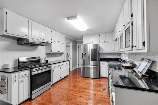 kitchen featuring stainless steel appliances, a sink, under cabinet range hood, white cabinetry, and light wood-style flooring