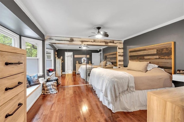 bedroom with ornamental molding and wood finished floors