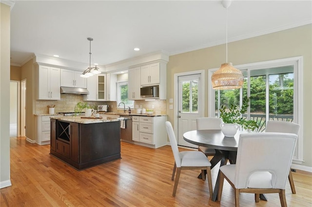 2802 Arabian Trl NE, Marietta, GA 30062 - kitchen featuring under cabinet range hood, appliances with stainless steel finishes, ornamental molding, decorative backsplash, and light wood-style flooring