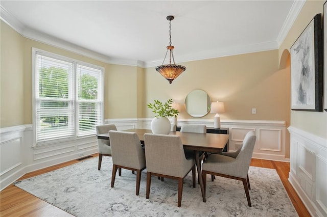 2802 Arabian Trl NE, Marietta, GA 30062 - dining space featuring wainscoting, ornamental molding, light wood-style floors, arched walkways, and a decorative wall