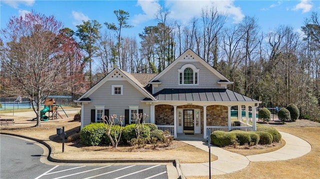 2802 Arabian Trl NE, Marietta, GA 30062 - view of front of property featuring a standing seam roof, a porch, a playground, stone siding, and metal roof
