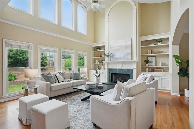 2802 Arabian Trl NE, Marietta, GA 30062 - living room featuring a high ceiling, a high end fireplace, wood finished floors, ceiling fan, and built in shelves