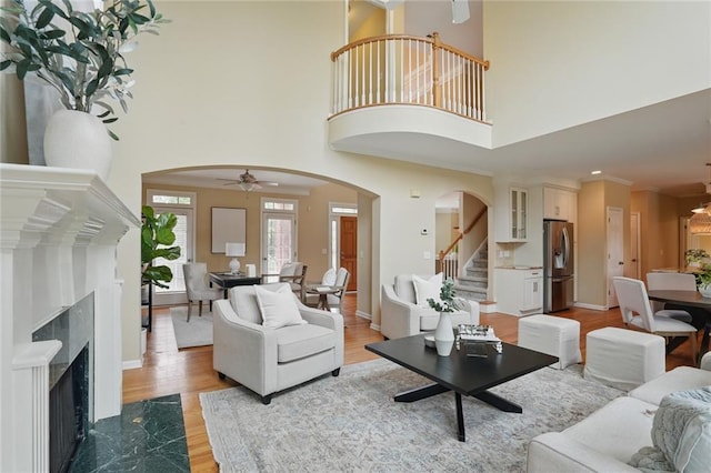 2802 Arabian Trl NE, Marietta, GA 30062 - living room featuring arched walkways, stairway, light wood-type flooring, a premium fireplace, and a ceiling fan